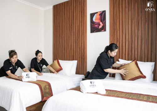 two women sitting on beds in a hotel room at The ONRA Hotel in Phnom Penh