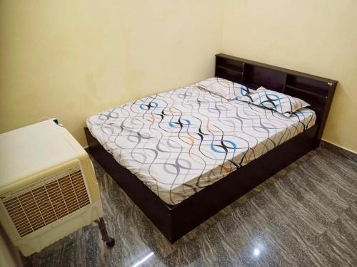 a bedroom with a bed and a fan at Hillview Homestay in Tiruvannāmalai