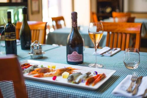 a table with a plate of food and a bottle of wine at Szerb Boutique Suites, by BQA in Budapest