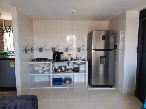 a kitchen with a stainless steel refrigerator and shelves at Acogedor apartamento en ibague 403 in Ibagué