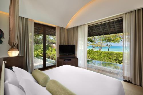 a bedroom with a bed and a view of the ocean at Vana Belle, A Luxury Collection Resort, Koh Samui in Chaweng Noi Beach