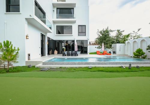 a house with a swimming pool in front of a building at Sirintara pool villa in San Sai