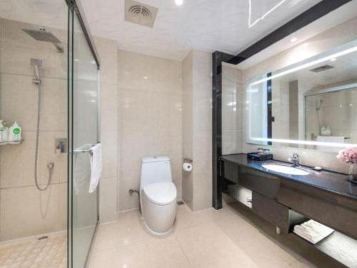 a bathroom with a toilet and a sink and a shower at Fuzhou Xin Zi Yang Hotel in Fuzhou