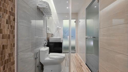 a bathroom with a white toilet and a shower at Fives Hotel DNP in Johor Bahru