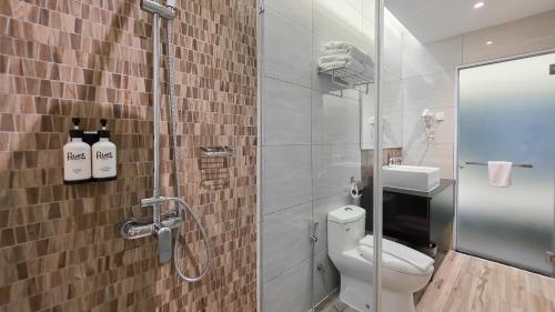 a bathroom with a shower with a toilet and a sink at Fives Hotel DNP in Johor Bahru