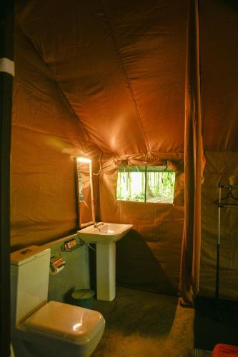 a bathroom with a toilet and a sink in a tent at Mango Safari Camping Udawalawe in Udawalawe