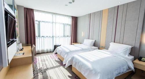 a hotel room with two beds and a large window at Lavande Hotel Yichang Railway East Station Branch in Yichang