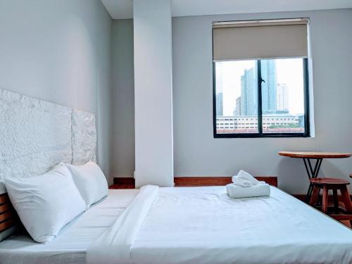 a bedroom with a large white bed with a window at Tonle Hostel in Phnom Penh