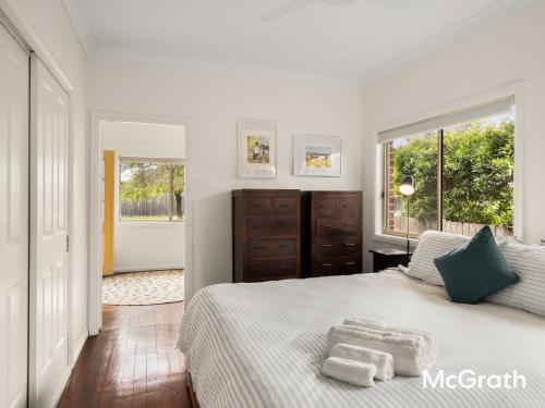 Mango Tree Cottage في ساوتيل: غرفة نوم بها سرير عليه منشفتان