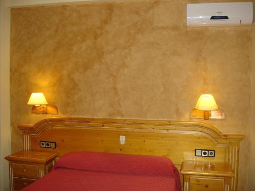 una camera con letto rosso e 2 comodini con lampade di Hotel Vista Nevada a Darro