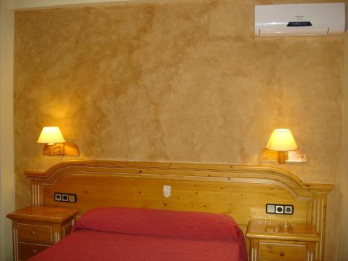 a bedroom with a red bed and two night stands with lamps at Hotel Vista Nevada in Darro