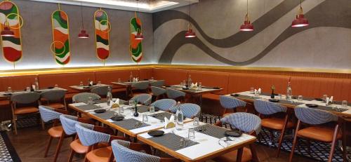 a restaurant with tables and chairs and surfboards on the wall at Mainland Resorts & Spa by Kolaahalam in Yercaud