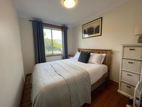 a small bedroom with a bed and a window at Spindrift Falmouth, adventurers coastal haven in Falmouth