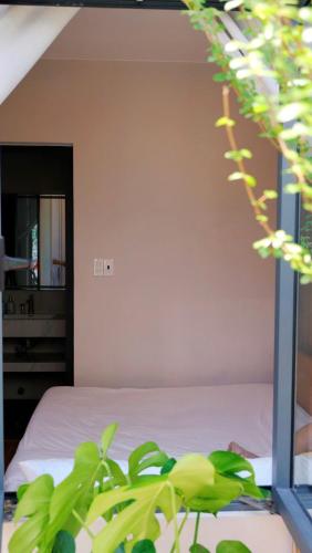 a bedroom with a bed and a plant at Adora Homestay Hue in Hue