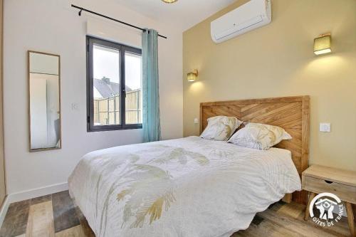 a bedroom with a large bed and a window at La source in Plouhinec