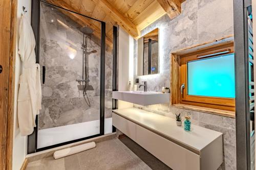 une salle de bain avec une baignoire, un lavabo et une douche dans l'établissement Luxury Chalet with Sauna & Jacuzzi in Megeve, à Megève