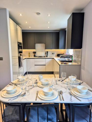 a kitchen with a table with wine glasses on it at Stylish Three Bedroom Ensuite Duplex Apartment in West Hampstead in London