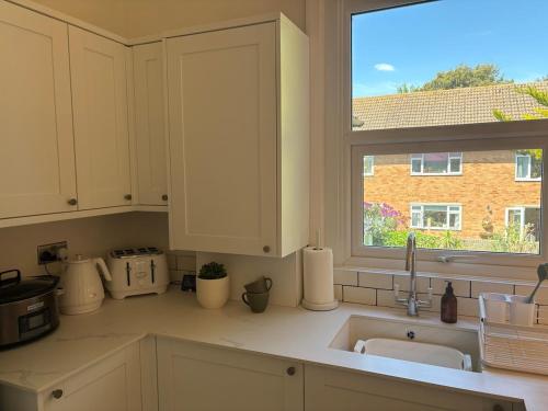 eine Küche mit Spüle und Fenster in der Unterkunft Pretty period property sleeps 4 guests with shared garden in Worthing