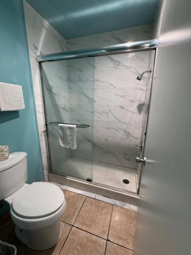 a bathroom with a glass shower with a toilet at Dream Inn in Inglewood