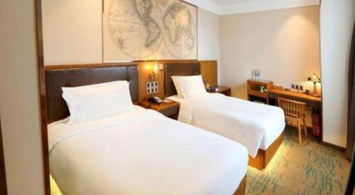 a hotel room with two beds and a desk at James Joyce Coffetel Changchun People's Square in Changchun