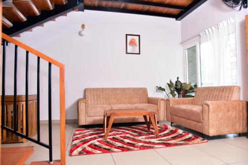 a living room with two chairs and a coffee table at Snow white resort wayanad in Wayanad