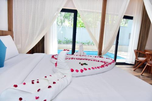 a bedroom with a bed with red roses on it at Snow white resort wayanad in Wayanad