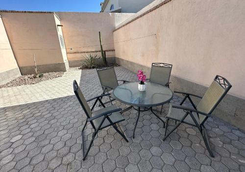 a glass table with four chairs and a vase with flowers at Casa completa, Hosp Angeles, Tec Mty y Facturamos in Torreón