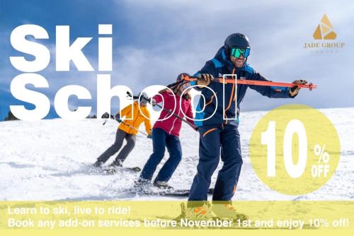 a man and two children on skis in the snow at MOMO HAKUBA by Jade Group in Hakuba