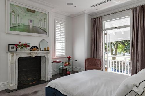 a bedroom with a white bed and a fireplace at The Darling Private Oasis with Heated Magnesium Pool in Sydney