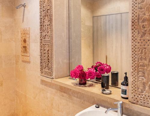 a bathroom with a sink and pink flowers on a shelf at The Darling Private Oasis with Heated Magnesium Pool in Sydney