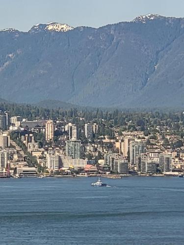 a boat in the water with a city and mountains at Downtown Center Silverstone Tower I and II Long-Term Booking Only Your second home in Vancouver in Vancouver