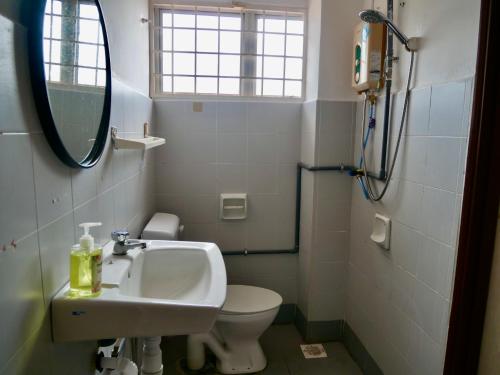 a bathroom with a sink and a toilet and a mirror at Homestay Cozy PD Villa, Port Dickson in Port Dickson