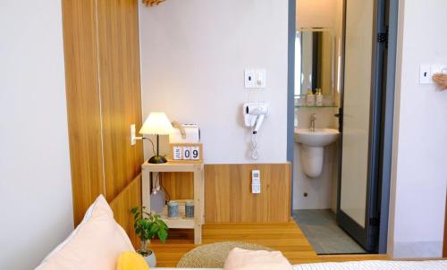 a bathroom with a sink and a phone on the wall at Adora Homestay Hue in Hue