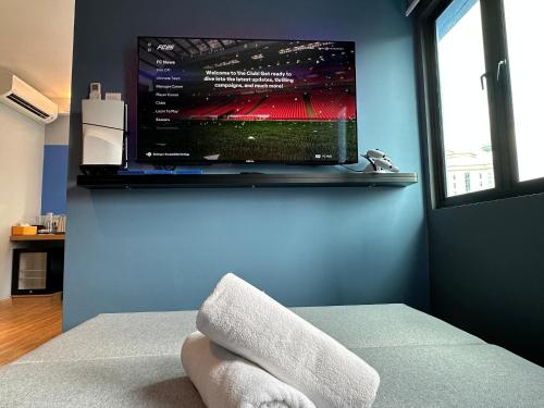 a room with a tv and a bed with towels at Blue Lagoon At Bandar Sunway in Petaling Jaya