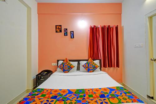 a bedroom with a bed with a colorful comforter at FabHotel Namaha Suites - Nr Hyderabad International Airport, Shamshabad in Hyderabad