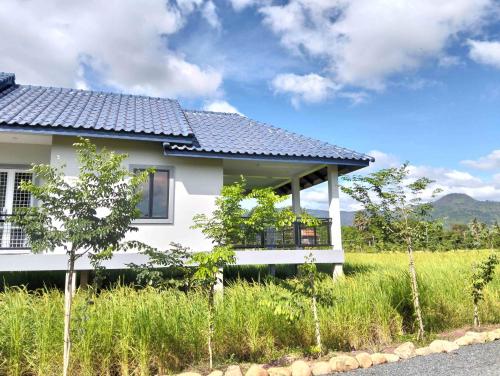 a white house with a black roof at Baksaei Retreat Ricefield Villas in Kampot