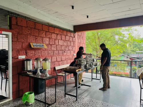 twee mensen die in een keuken eten klaarmaken bij Heaven Hills resorts in Vythiri