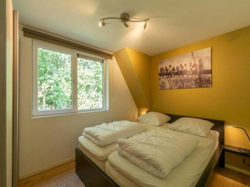 Holiday Home Groote Keeten near Beaches في جروت كيتين: سرير مع وسائد بيضاء في غرفة مع نافذة