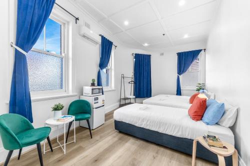 una camera da letto con un letto e due sedie verdi di Stay Today Hostel a Sydney
