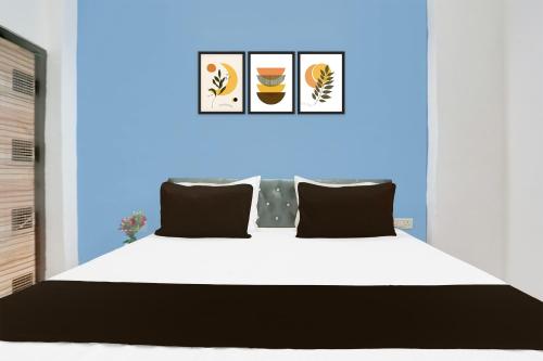 a bedroom with a white bed and a blue wall at Super Hotel O Dream Palace in Delhi