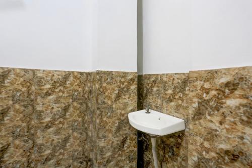 a bathroom with a sink and a wall at Super Hotel O Dream Palace in Delhi