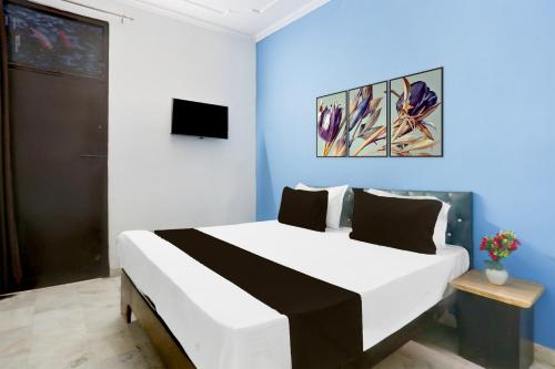 a bedroom with a large bed with a blue wall at Super Hotel O Dream Palace in Delhi