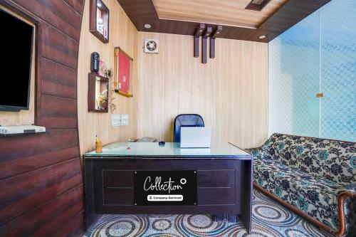 a hotel room with a bed and a desk in a room at Collection O Kedarpuram doon university in Dehradun