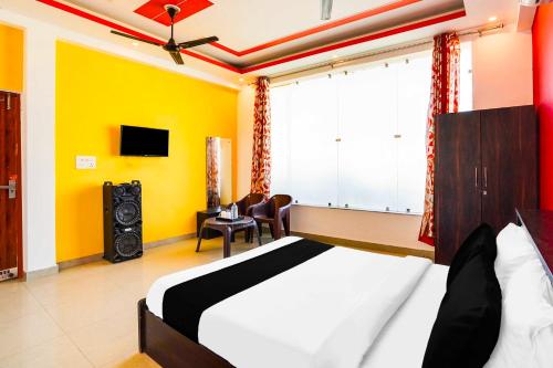 a bedroom with a bed and a tv in a room at Collection O Kedarpuram doon university in Dehradun