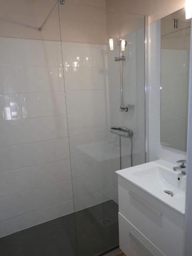 une salle de bain blanche avec une douche et un lavabo dans l'établissement Domaine de Ravel Ushuaïa Villages, à Saint-Jean-du-Gard