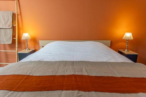 une chambre avec un grand lit avec deux lampes dans l'établissement Parenthèse idéale Chambre O double face dans villa face mer à Carnac, à Carnac