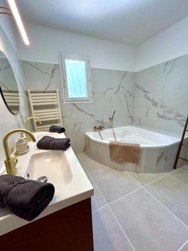 une salle de bain blanche avec une baignoire et un lavabo dans l'établissement Maison contemporaine piscine, à Six-Fours-les-Plages