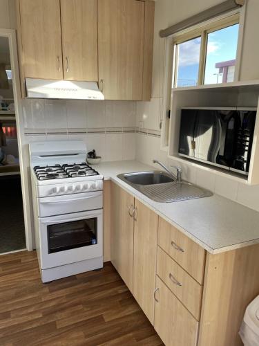 a kitchen with a white stove and a sink at Barwon River Holiday Park in Geelong