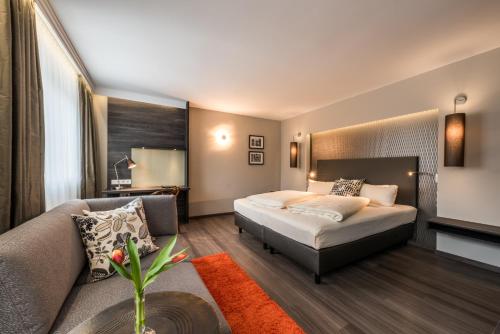 pokój hotelowy z łóżkiem i kanapą w obiekcie Hotel Säntis w Monachium