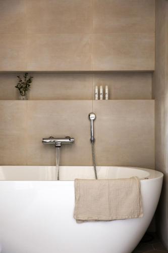 a bath tub with a towel on the side of it at Tukkilan Tila in Porvoo